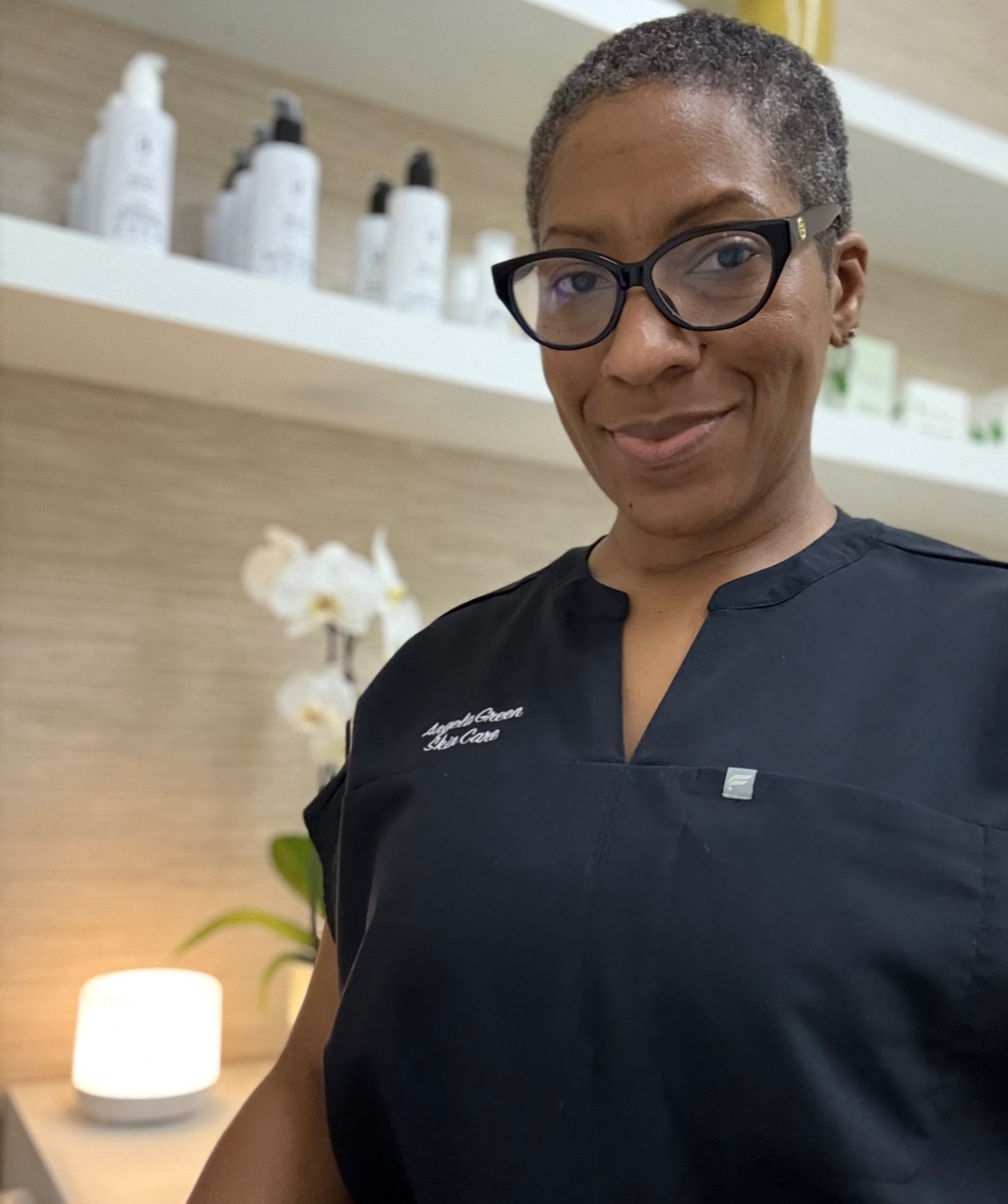 Angela Green smiling in her studio in front of shelves of a.dot products