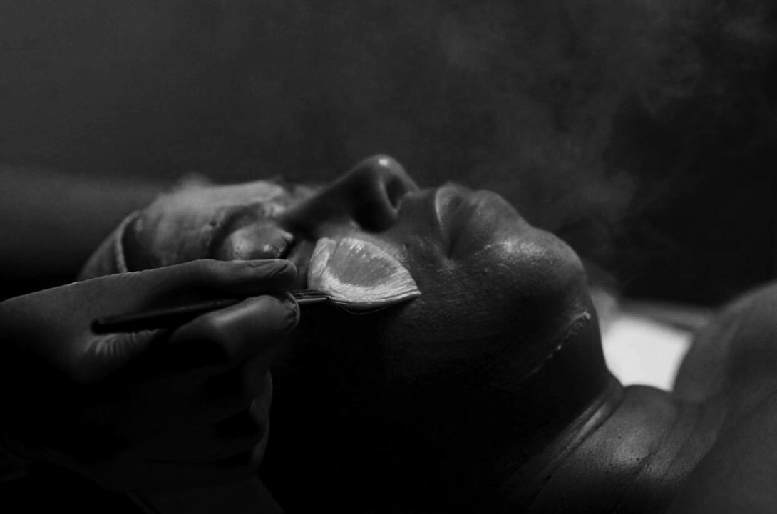 A fan brush applying a treatment during a facial